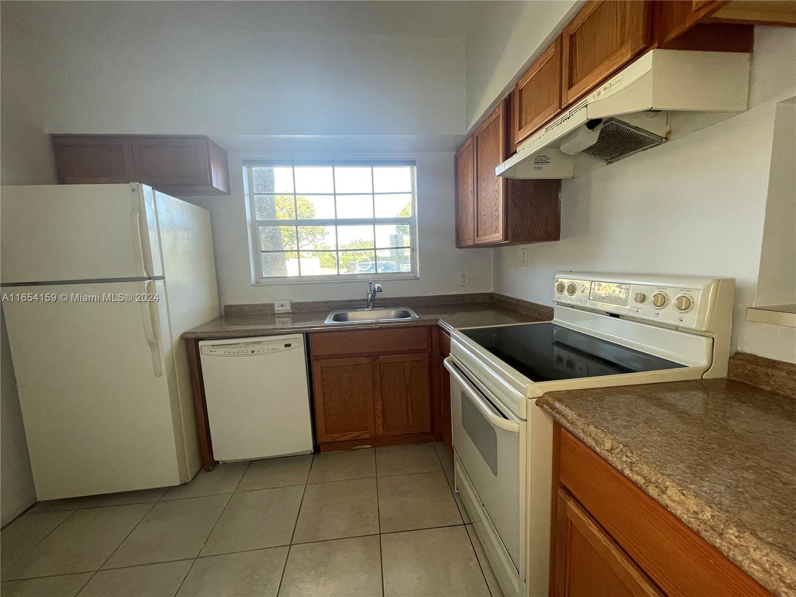 a kitchen with a stove sink and refrigerator