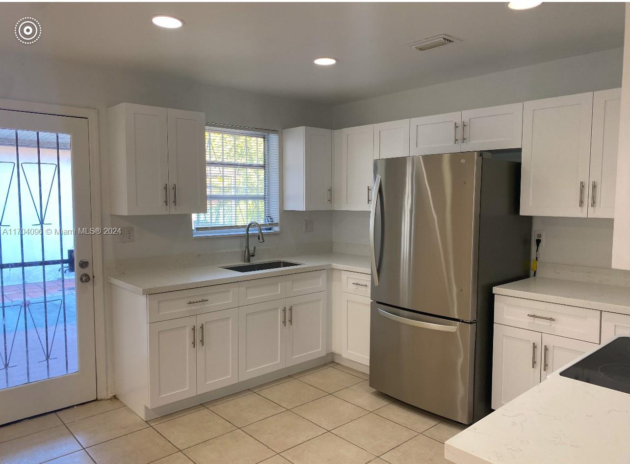 a kitchen with a refrigerator sink and cabinets