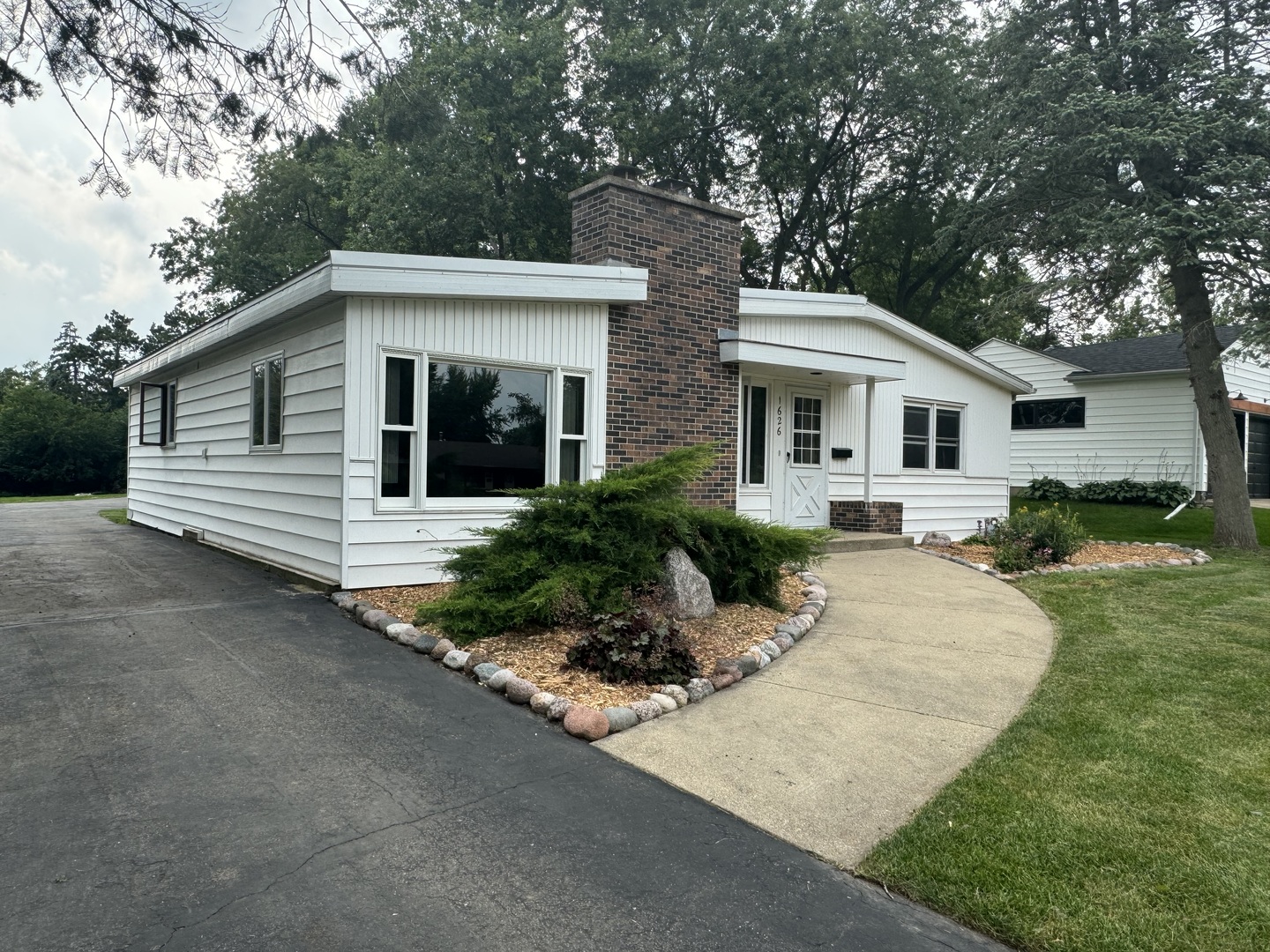 a front view of a house with a garden