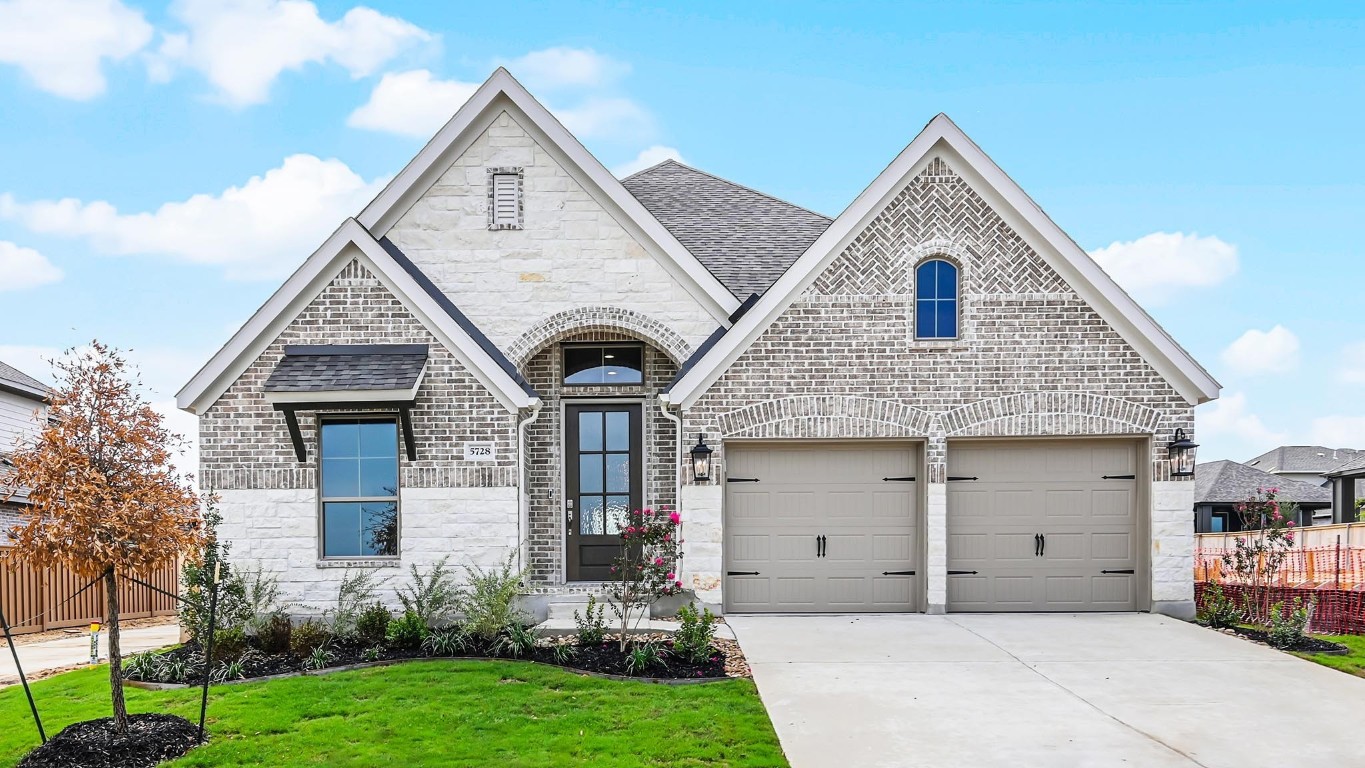 a front view of a house with a yard and garage