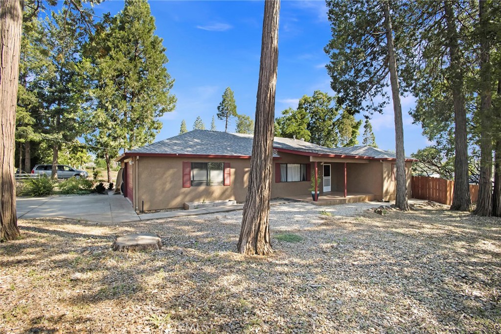 a view of a house with a yard tree and a fence