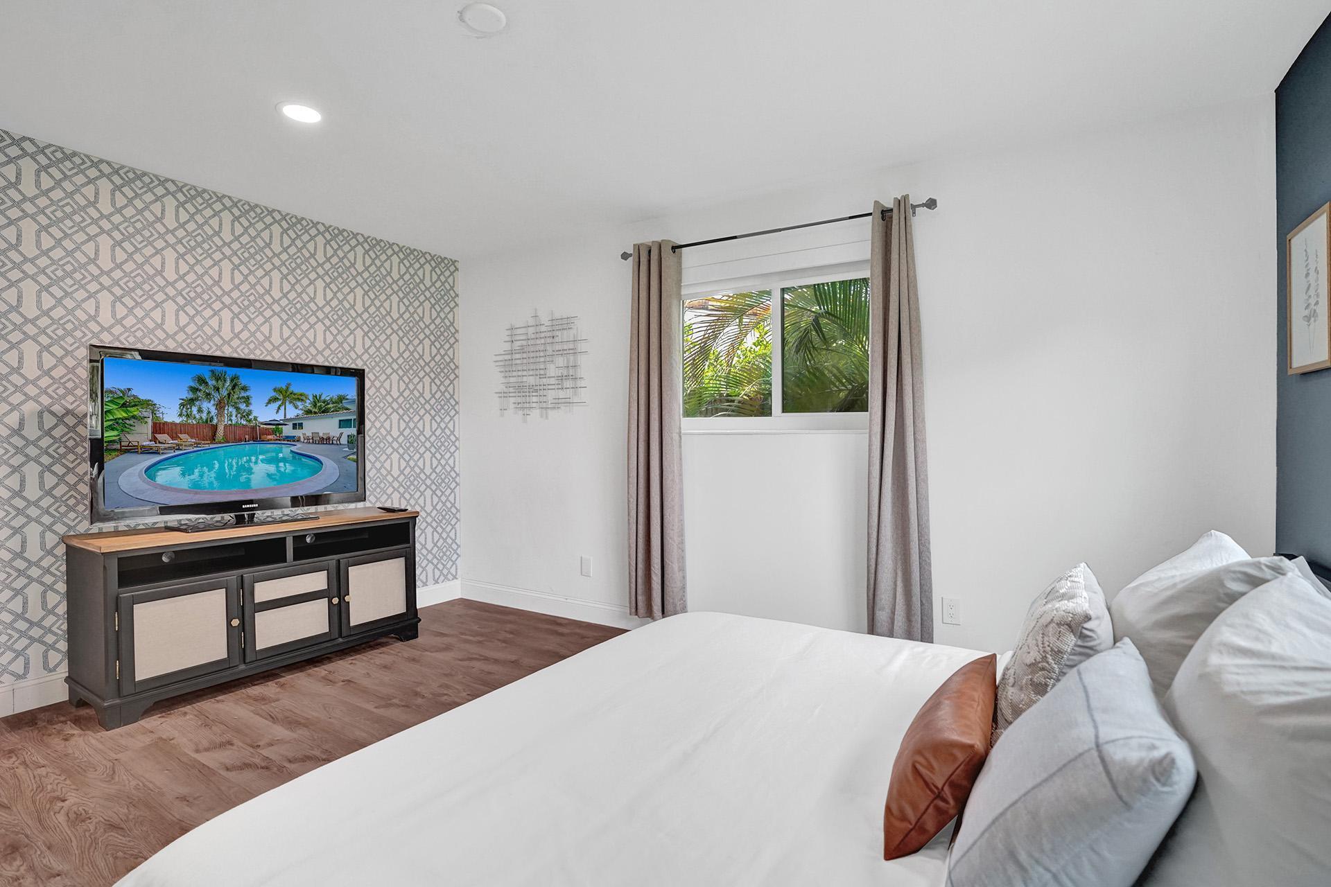 a bedroom with a bed and a flat screen tv