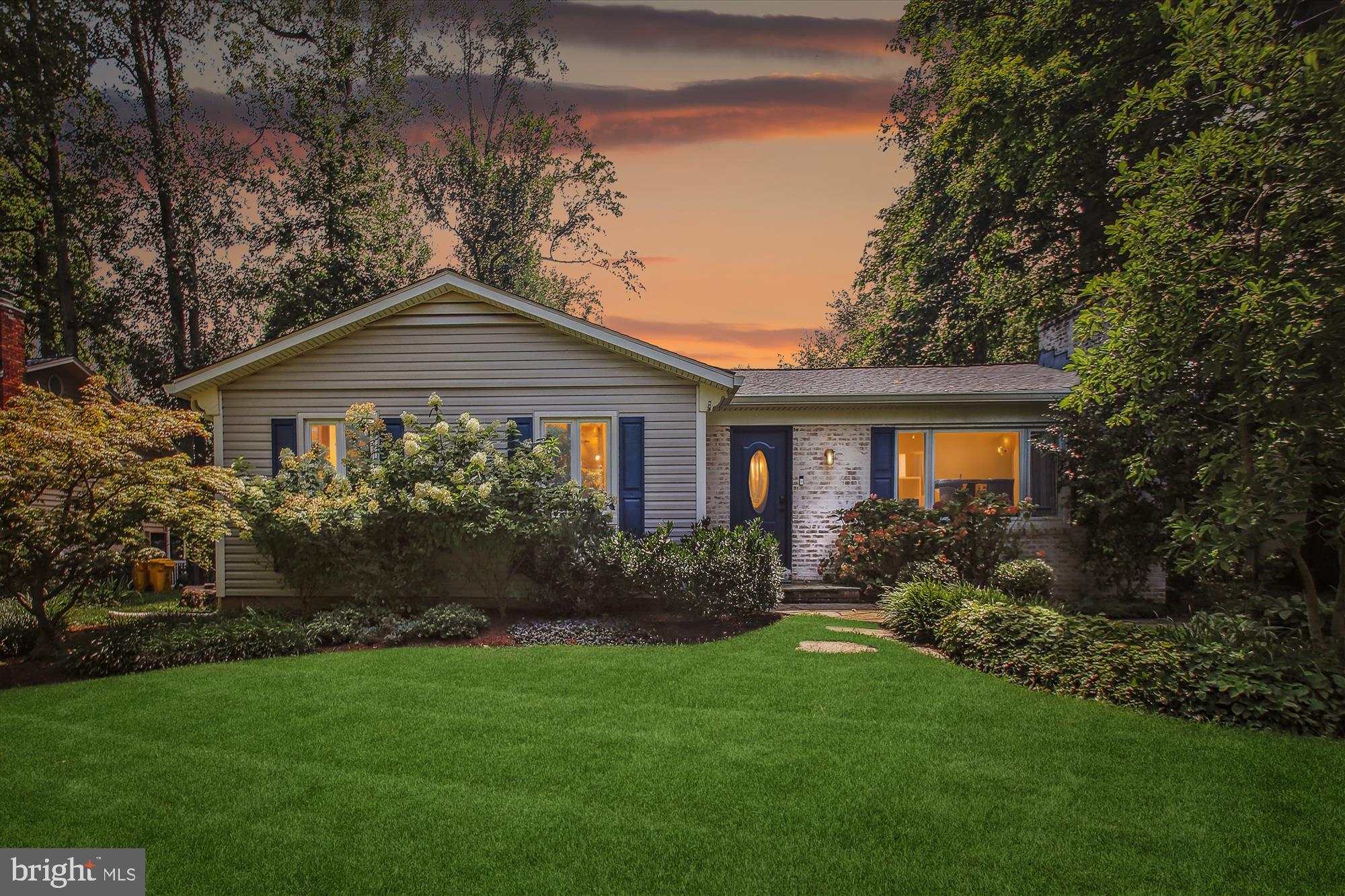 a front view of a house with a yard and trees