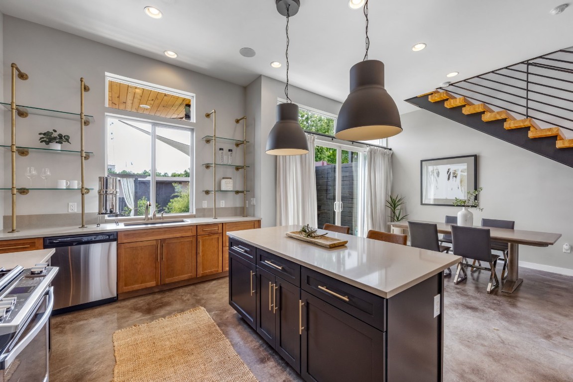 a kitchen with stainless steel appliances granite countertop a stove a sink and a refrigerator