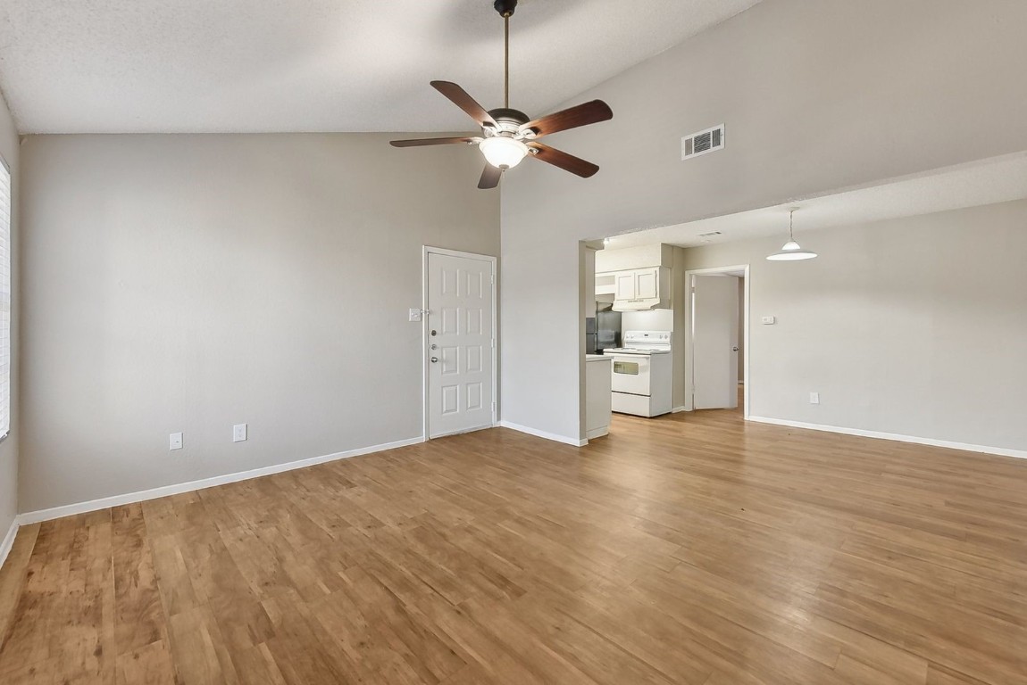 a view of a room with a ceiling fan window and wooden floor