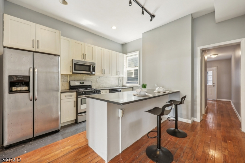 a kitchen with kitchen island a white counter top space cabinets and stainless steel appliances