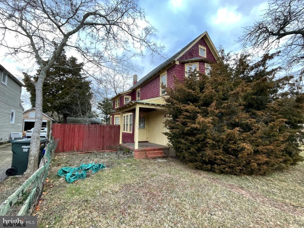 a front view of house with yard and trees in the background