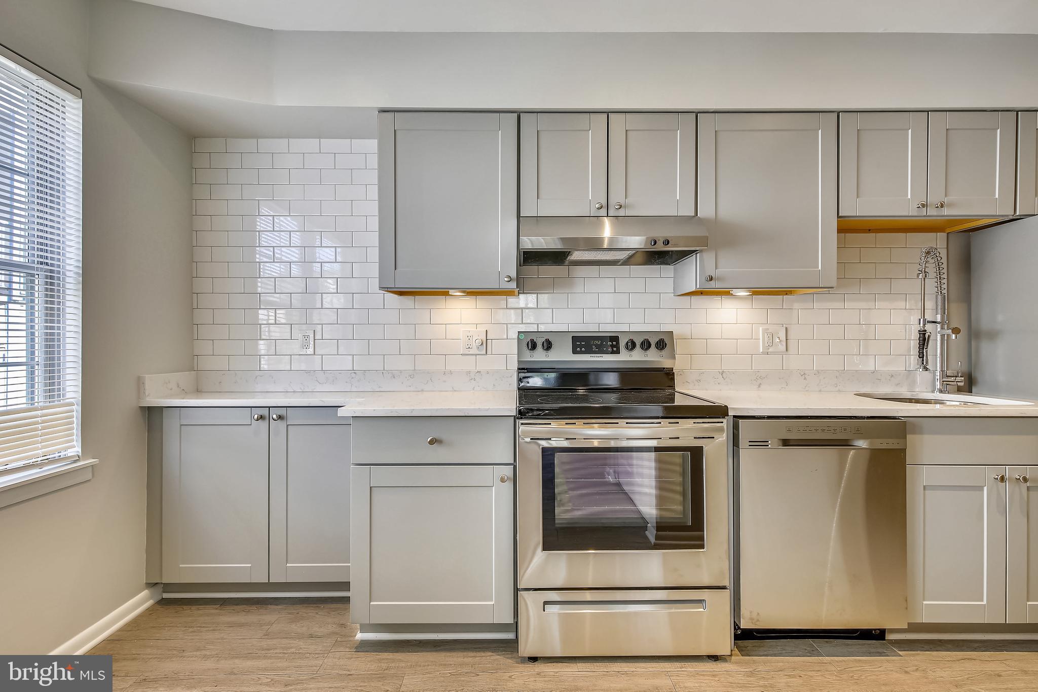 a kitchen with granite countertop white cabinets and appliances