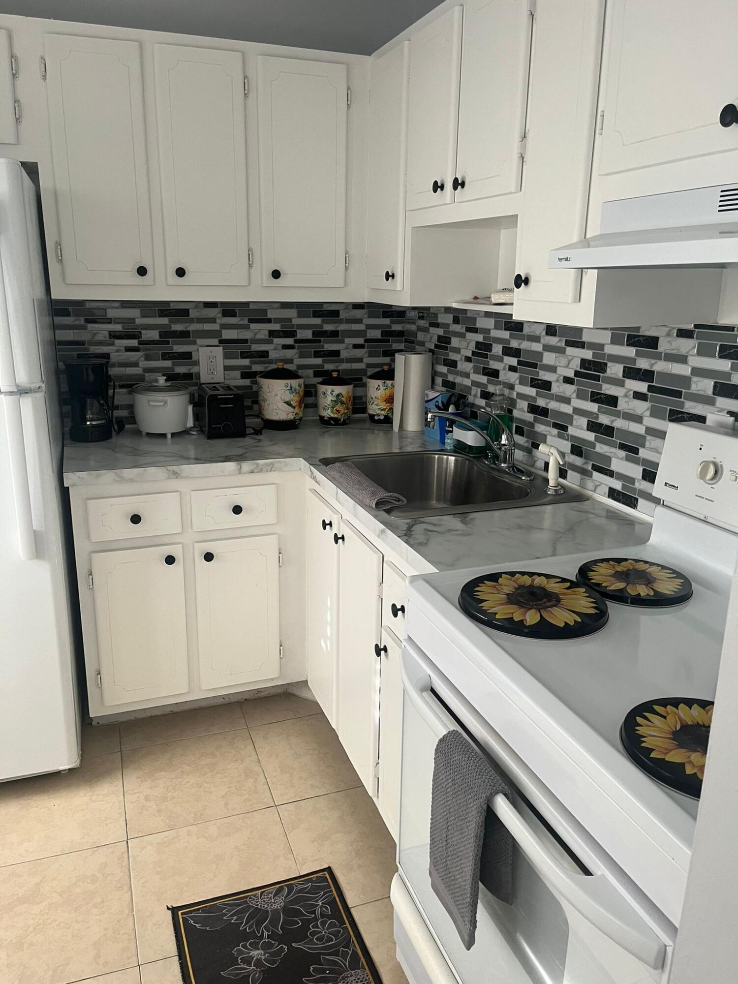 a kitchen with white cabinets and appliances