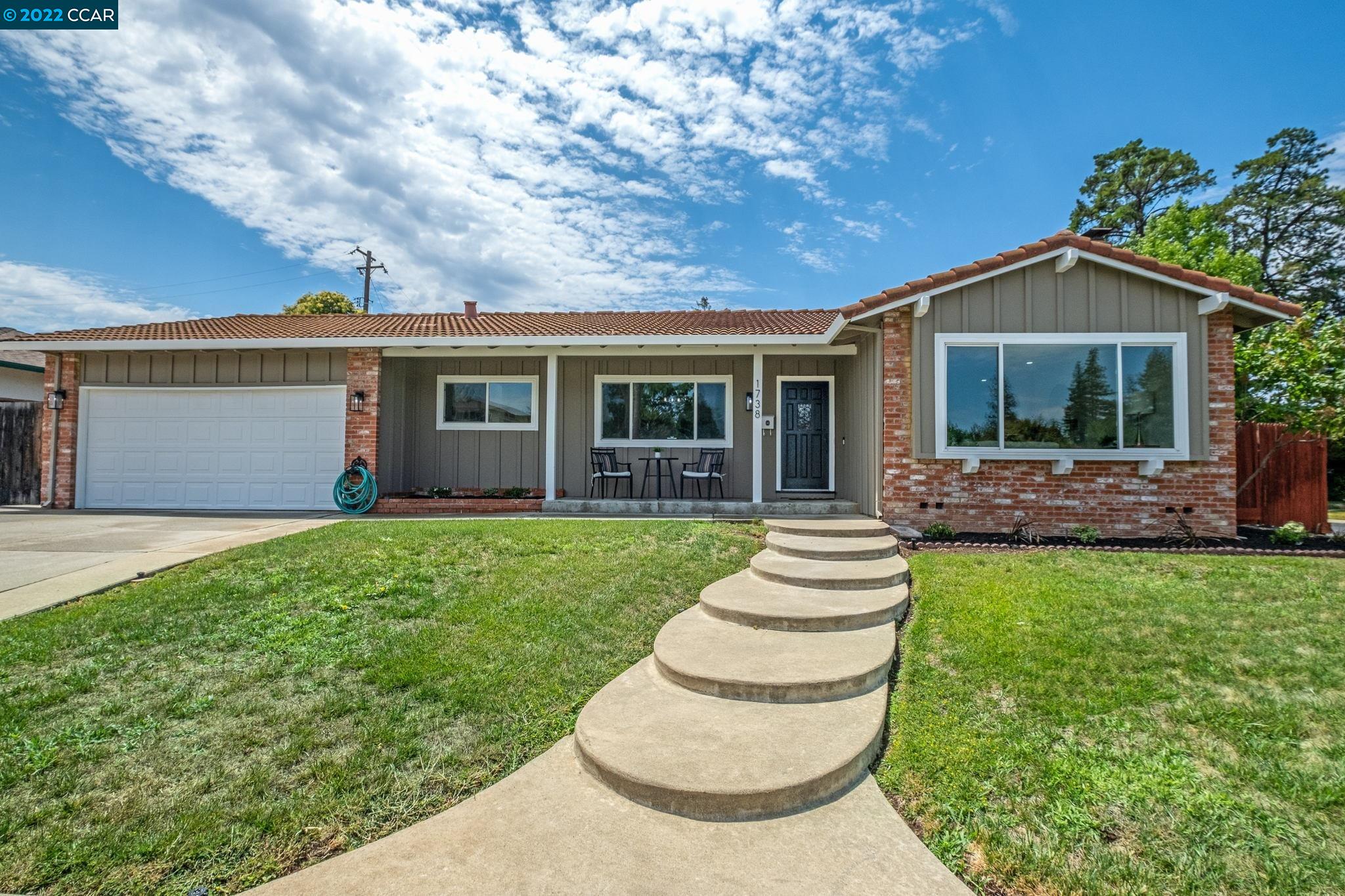 a front view of a house with a garden and yard