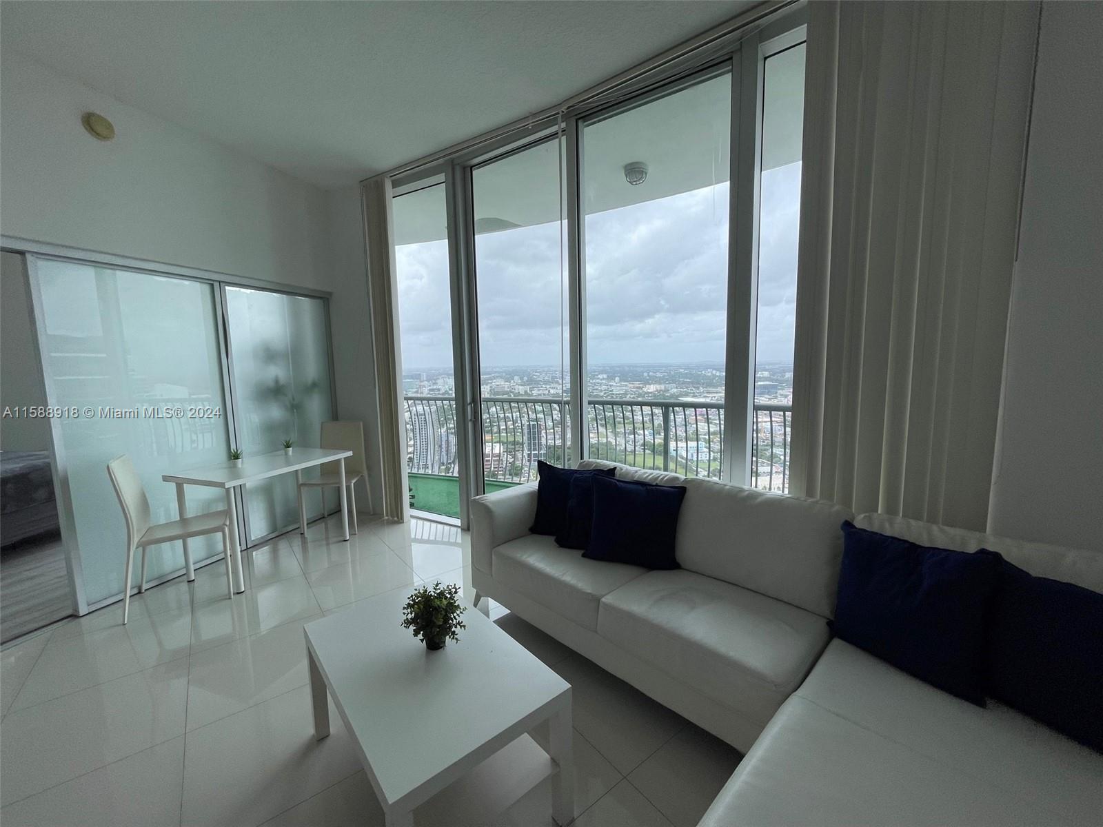 a living room with furniture and a floor to ceiling window