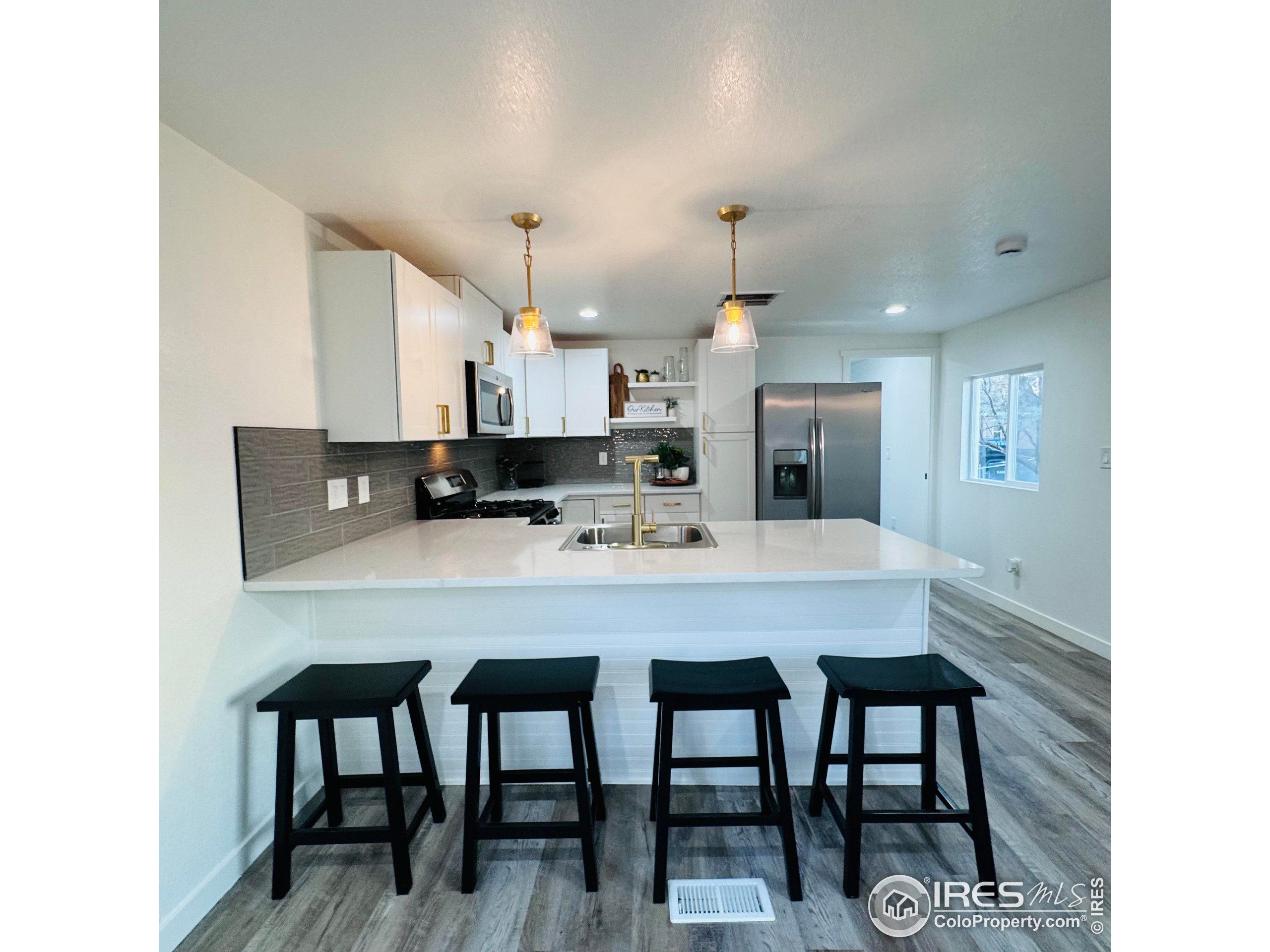 a kitchen with kitchen island a dining table chairs and white cabinets