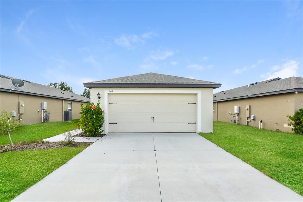 a front view of a house with a yard and garage