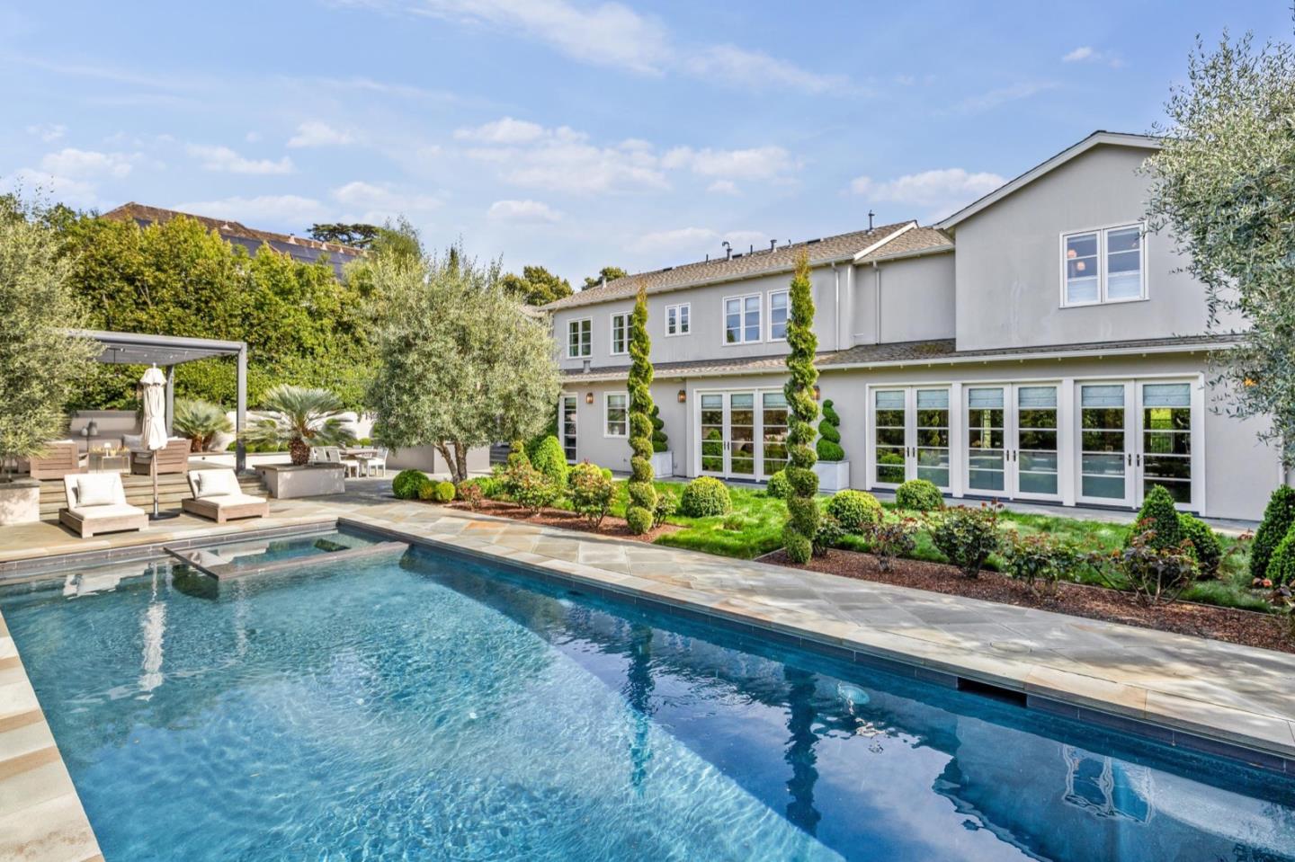 a front view of a house with a garden and outdoor seating