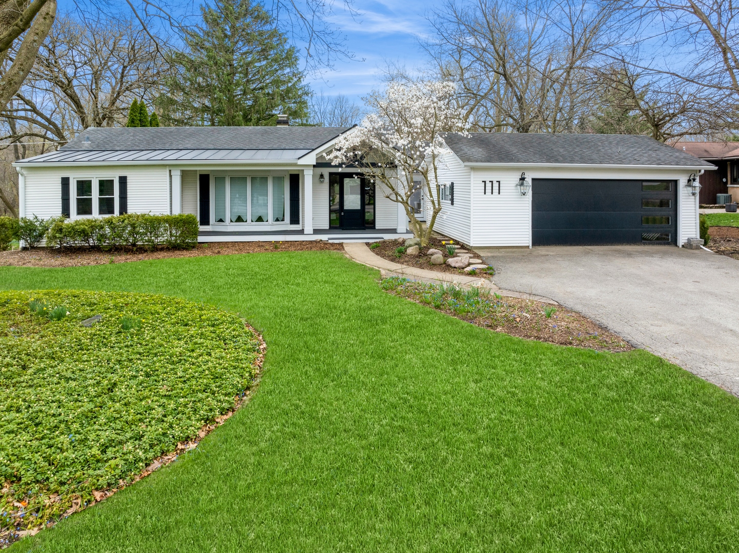 a front view of a house with a garden and yard