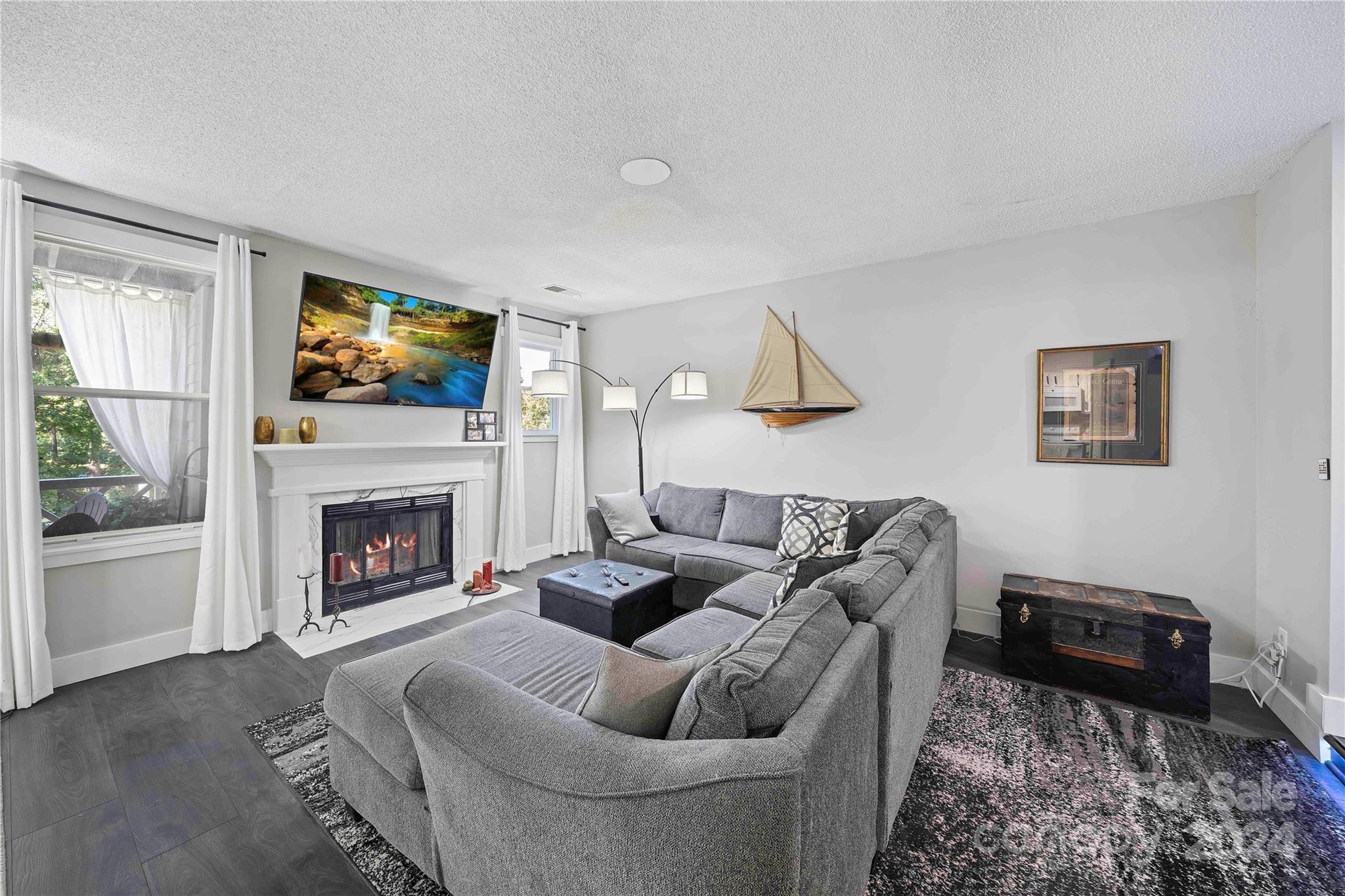 a living room with furniture a flat screen tv and a fireplace