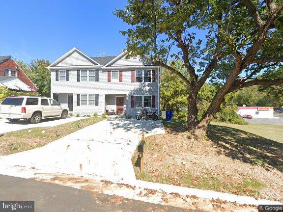 a view of a white house with a yard covered with snow