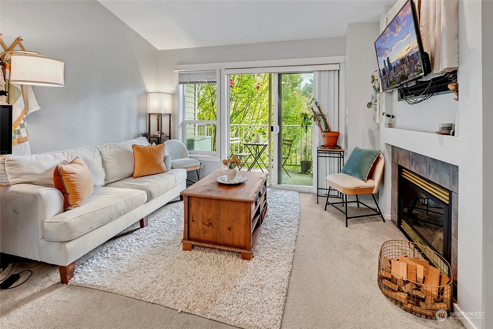 a living room with furniture a fireplace a flat screen tv and a window