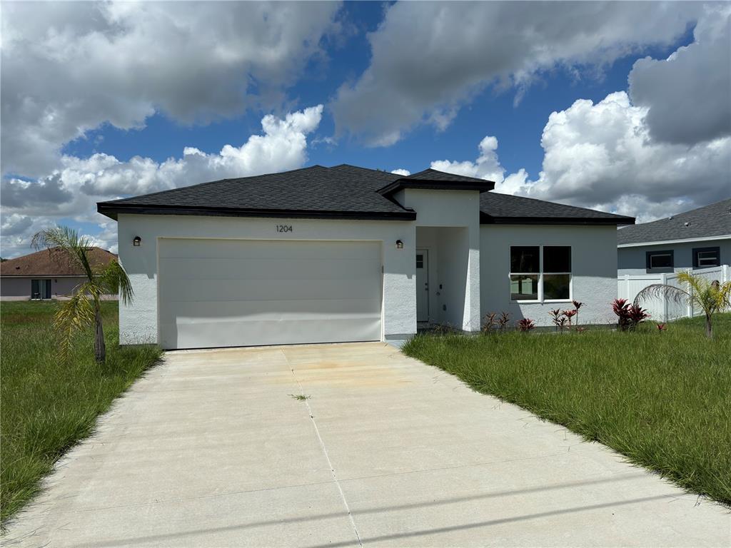 a front view of a house with a garden and a garage