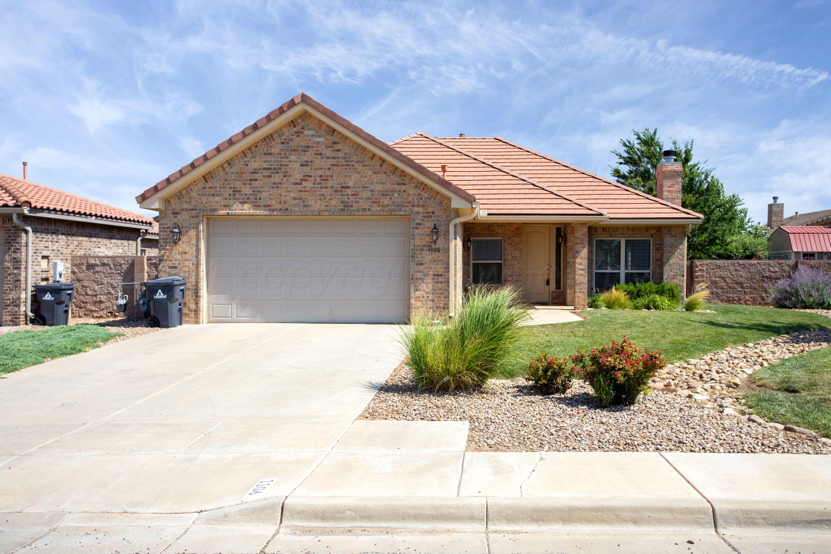 a front view of a house with a yard and potted plants