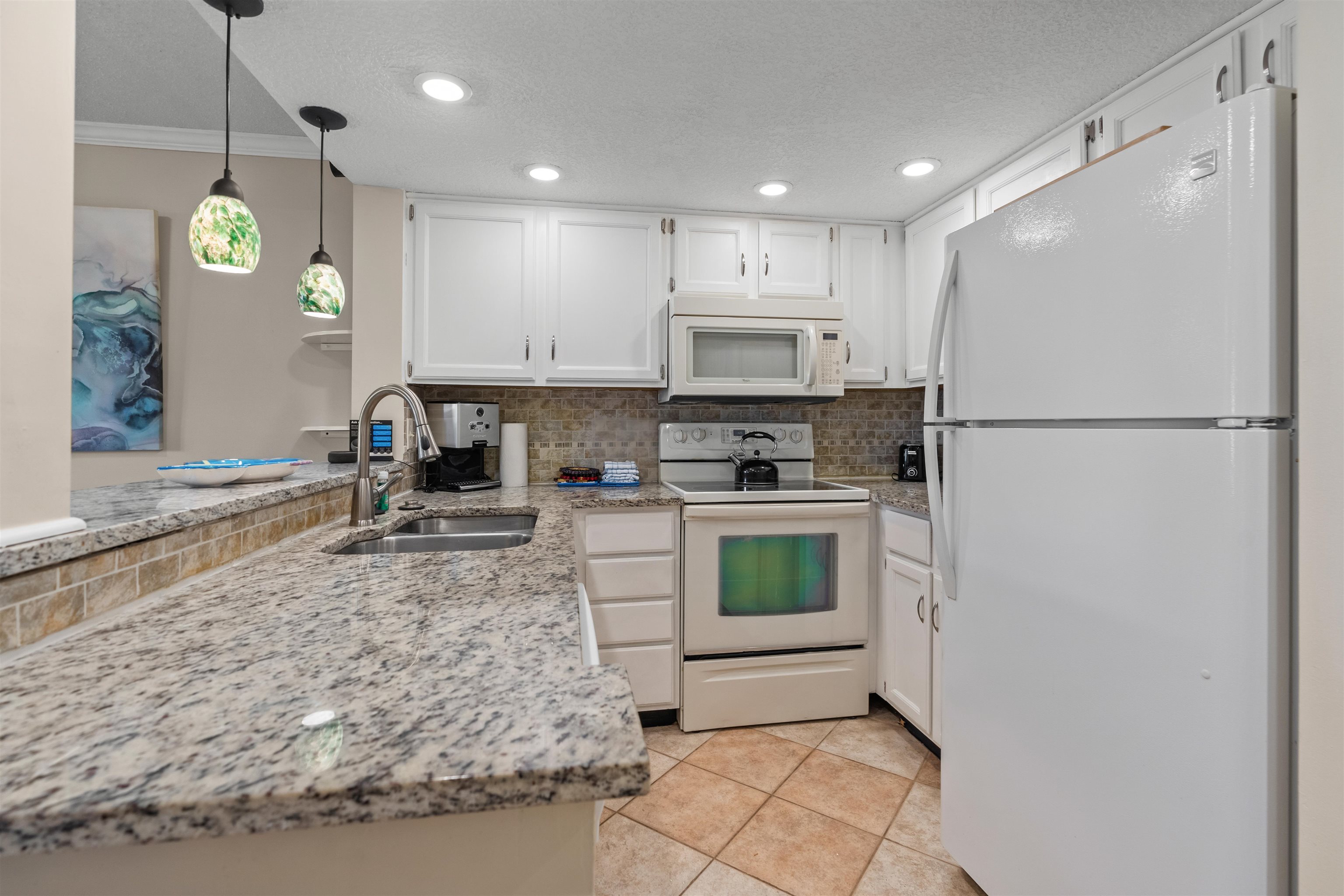 a kitchen with a refrigerator a stove and a sink