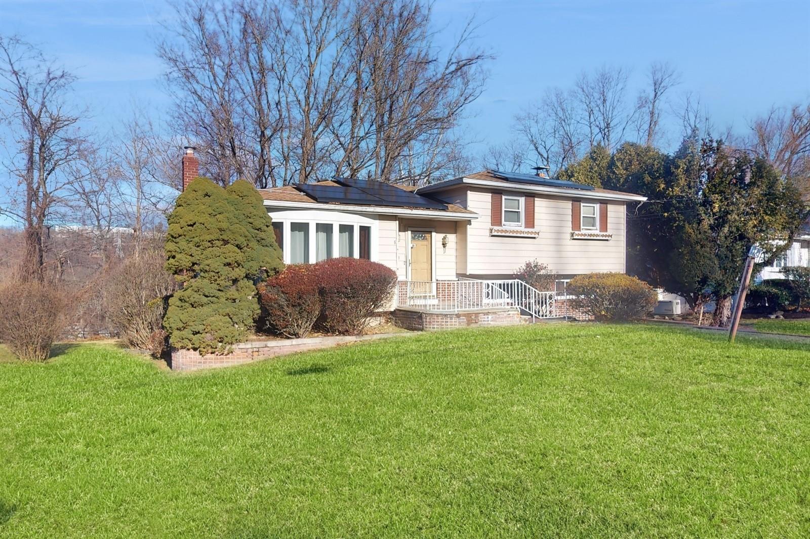 Split level home with a front yard and solar panels