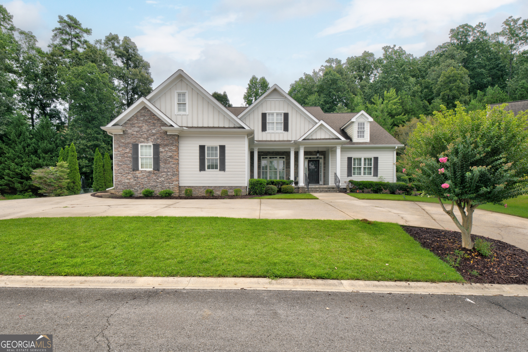 a front view of a house with a garden and yard