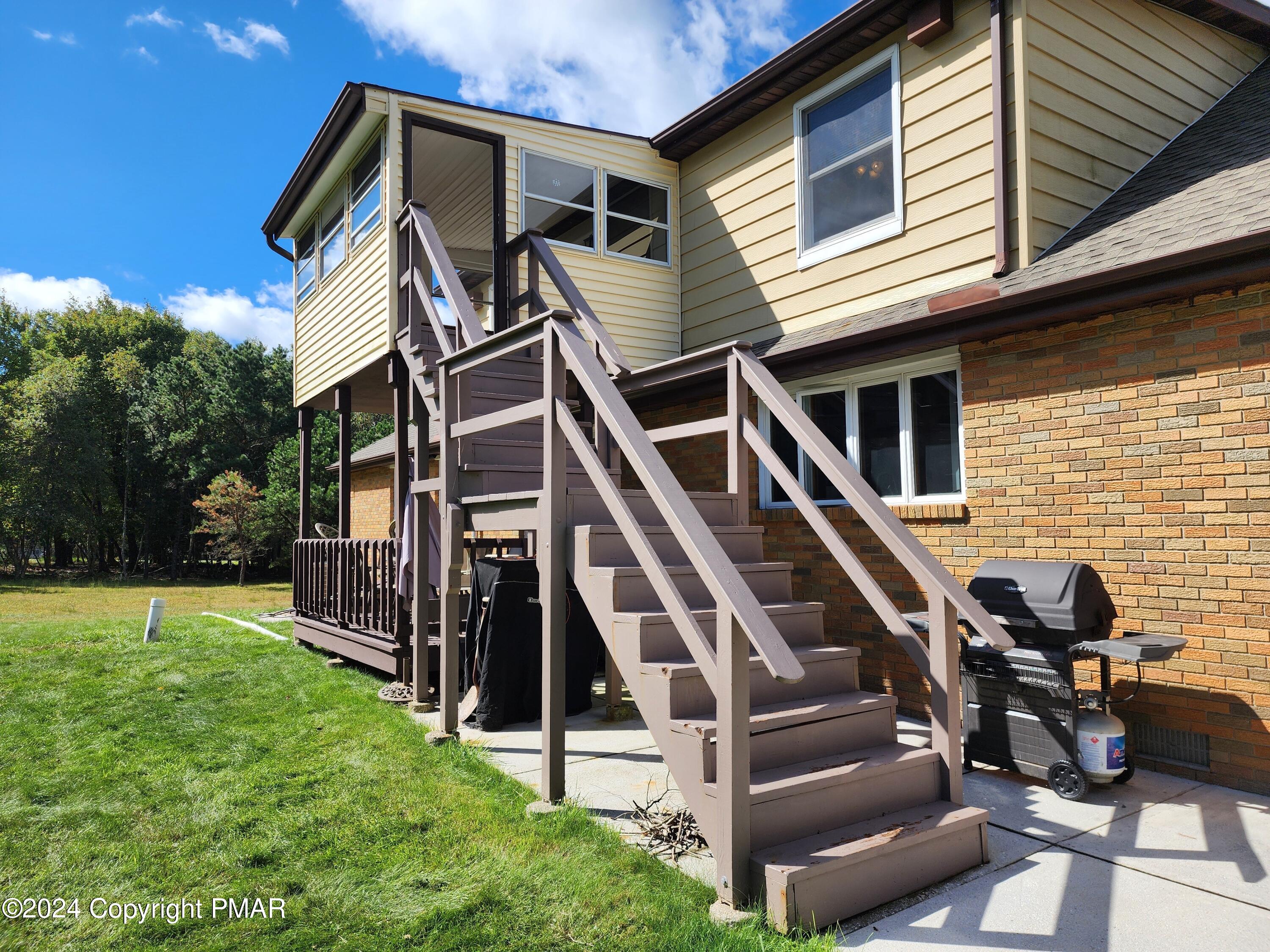 a view of a house with backyard and deck