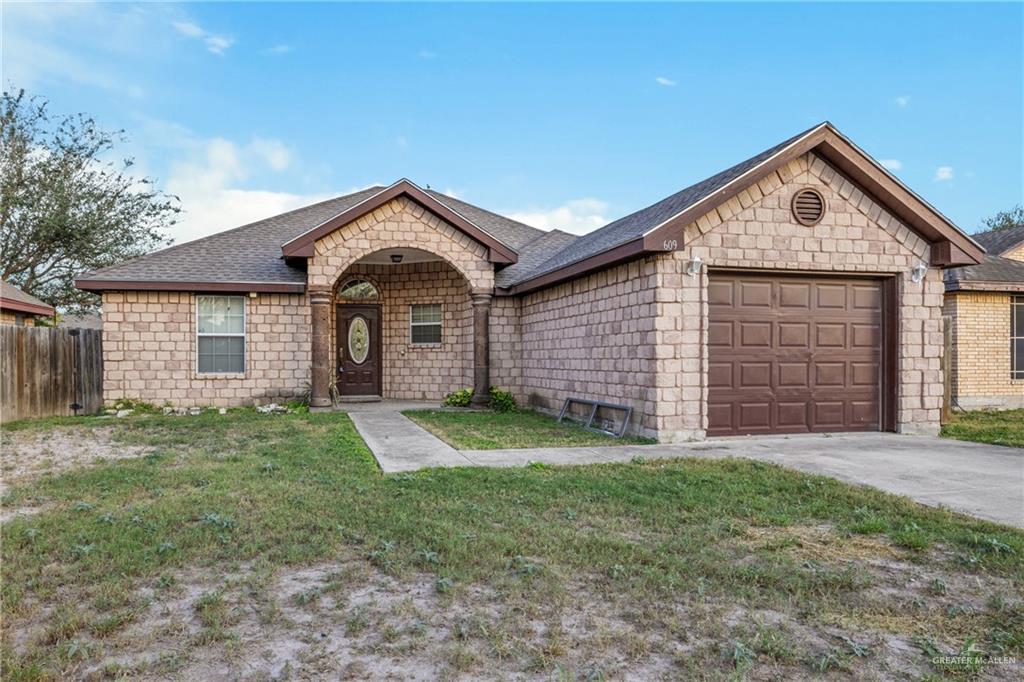 Ranch-style house with a front lawn and a garage