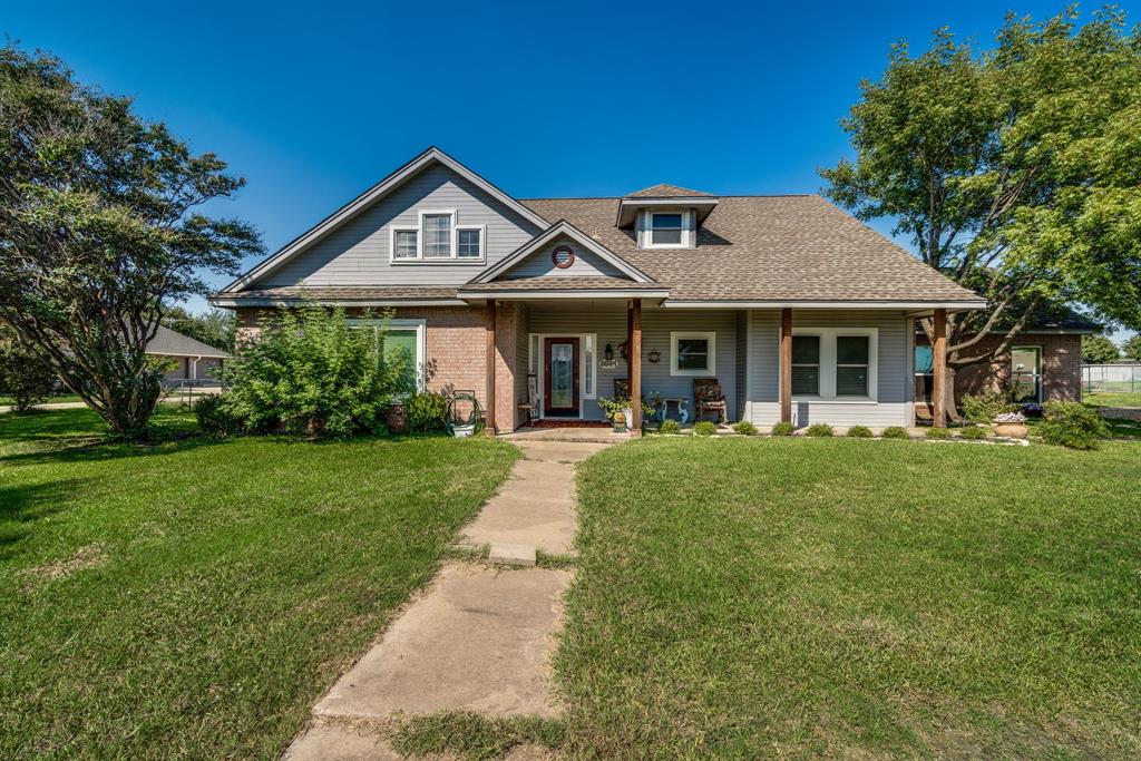 a front view of a house with a yard and green space