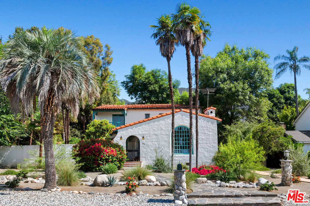 a front view of a house with a garden