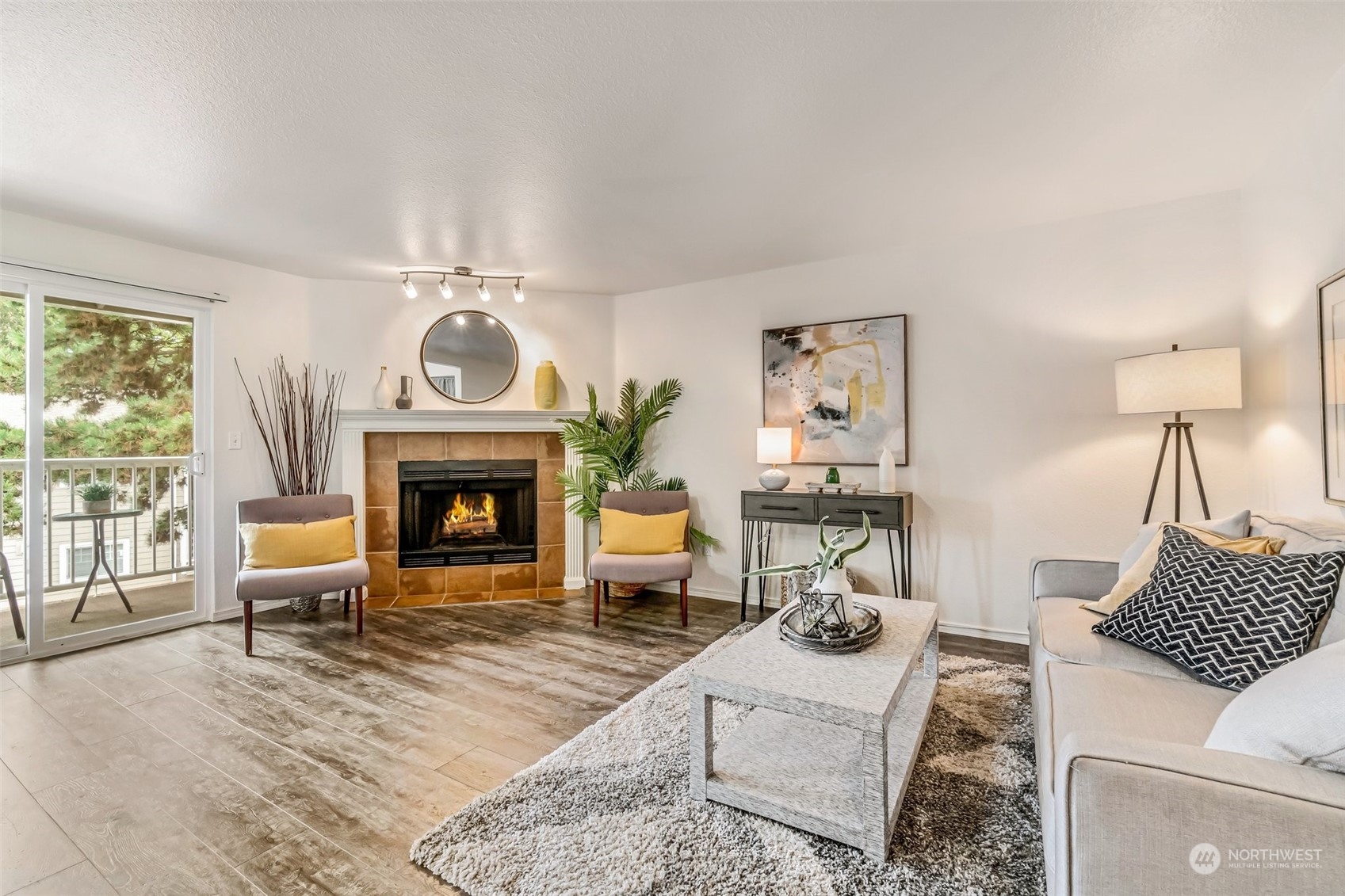 a living room with furniture a fireplace and a large window