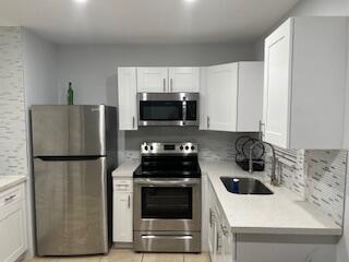 a kitchen with a refrigerator and a stove top oven