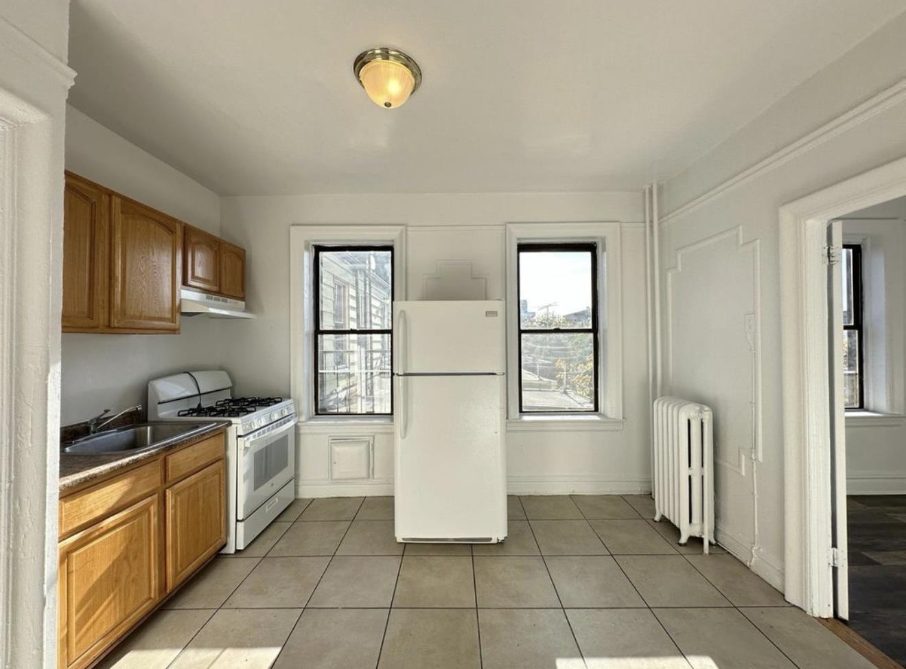 a kitchen with a refrigerator a stove top oven and cabinets