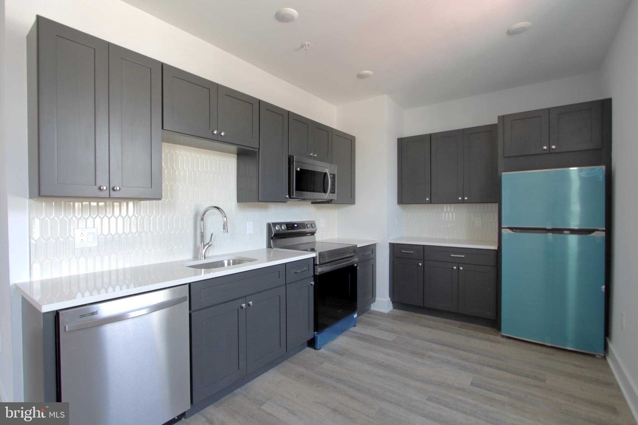 a kitchen with a sink a refrigerator and wooden cabinets