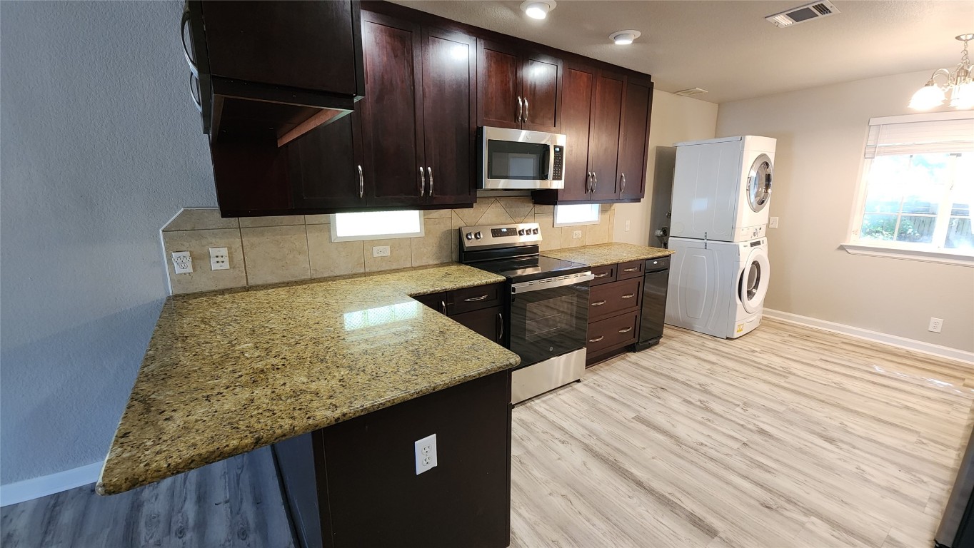 a kitchen with stainless steel appliances granite countertop a sink stove and refrigerator