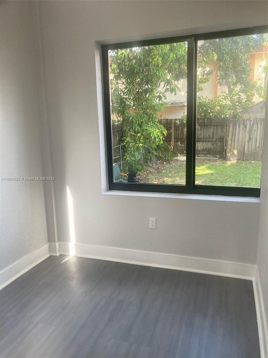 a view of a room with wooden floor and a window