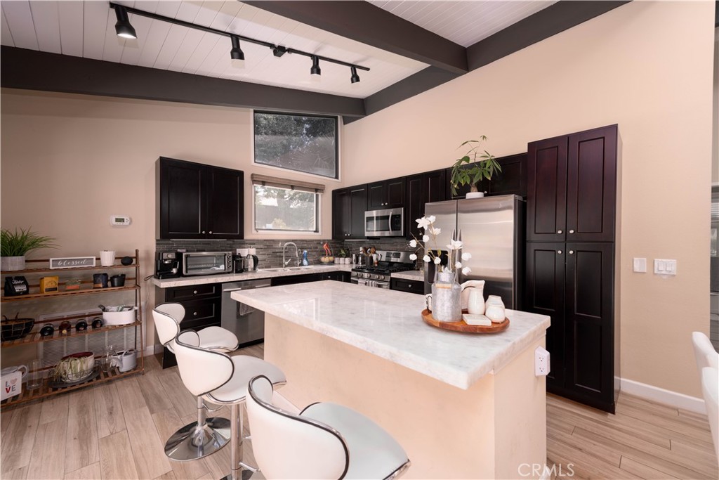 a kitchen with a refrigerator a stove and a wooden floor