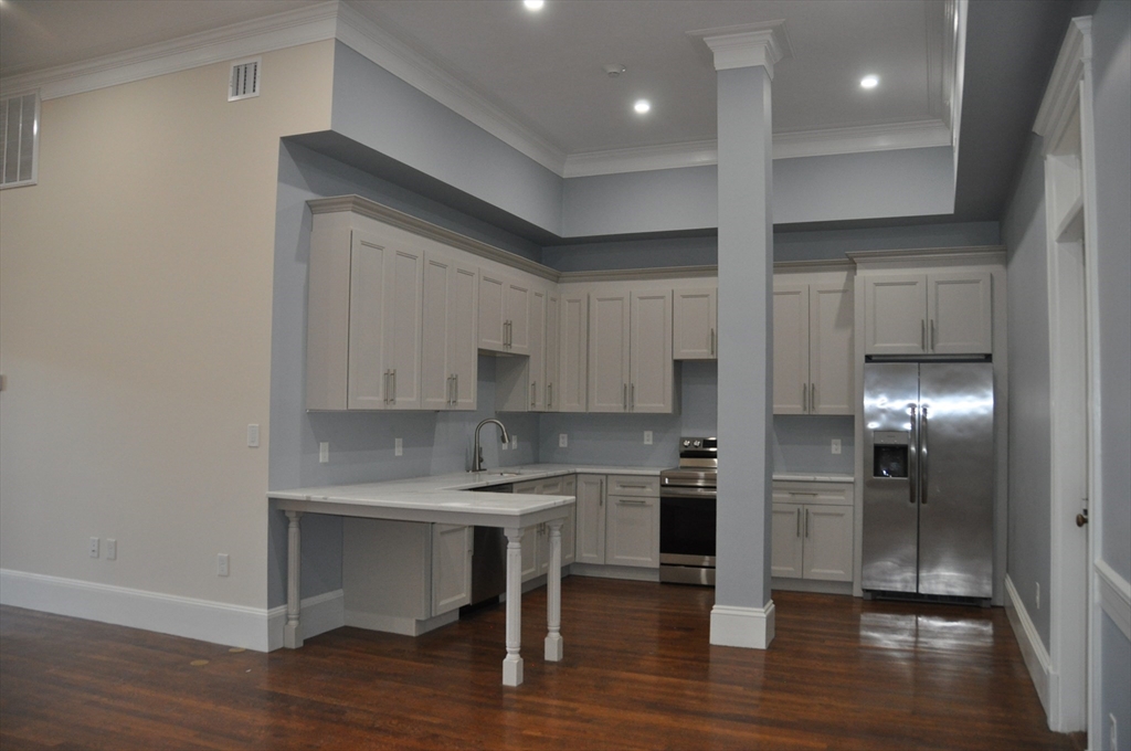 a kitchen with kitchen island stainless steel appliances a sink and cabinets