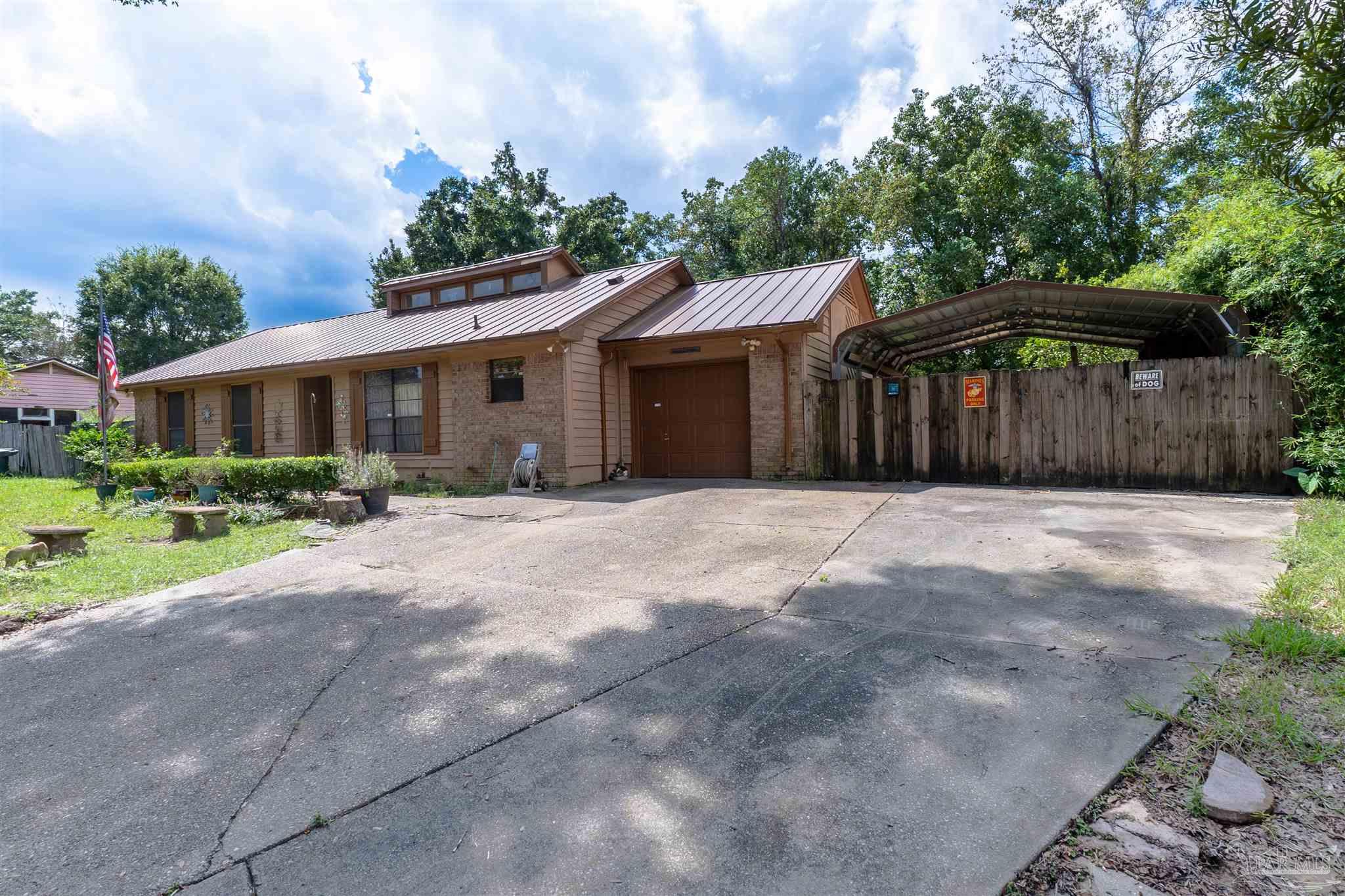 a front view of house with yard and trees around