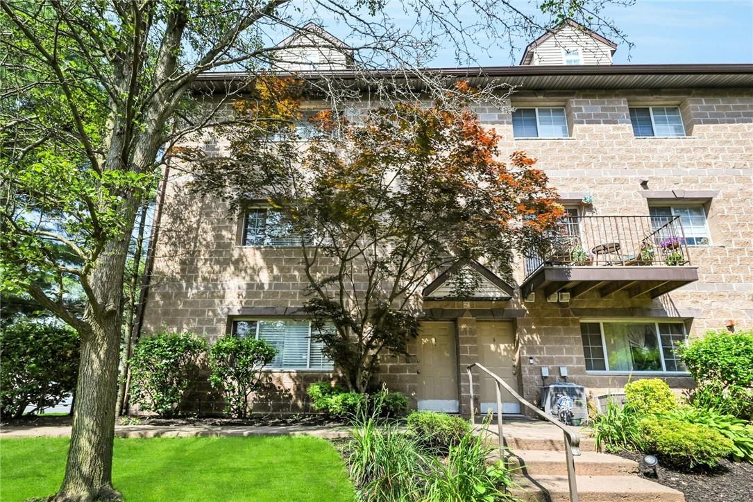 Townhome / multi-family property featuring a balcony and a front lawn