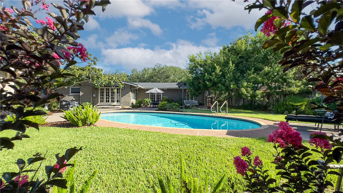 a view of a backyard with swimming pool