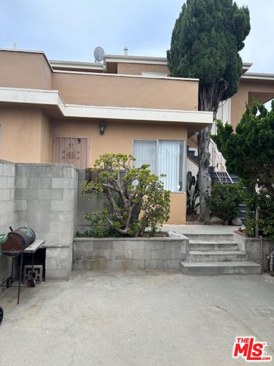 a view of a house with a patio and a yard