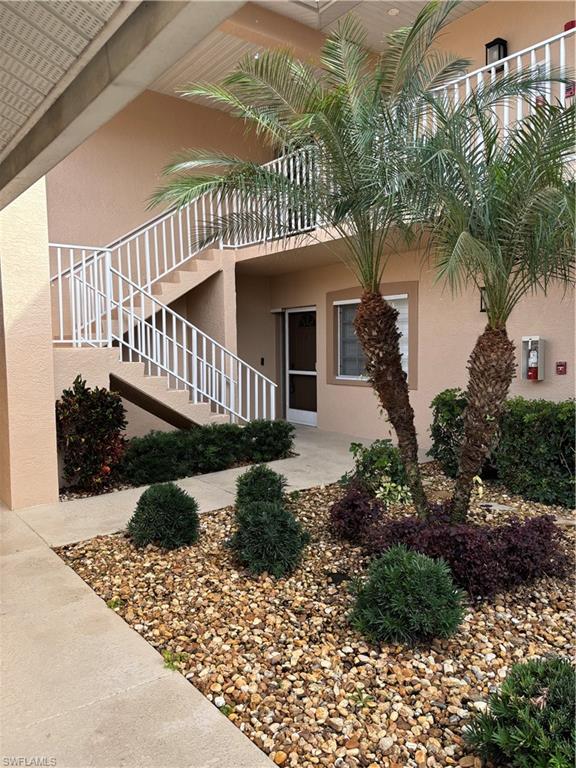 a view of a house with a yard and potted plants