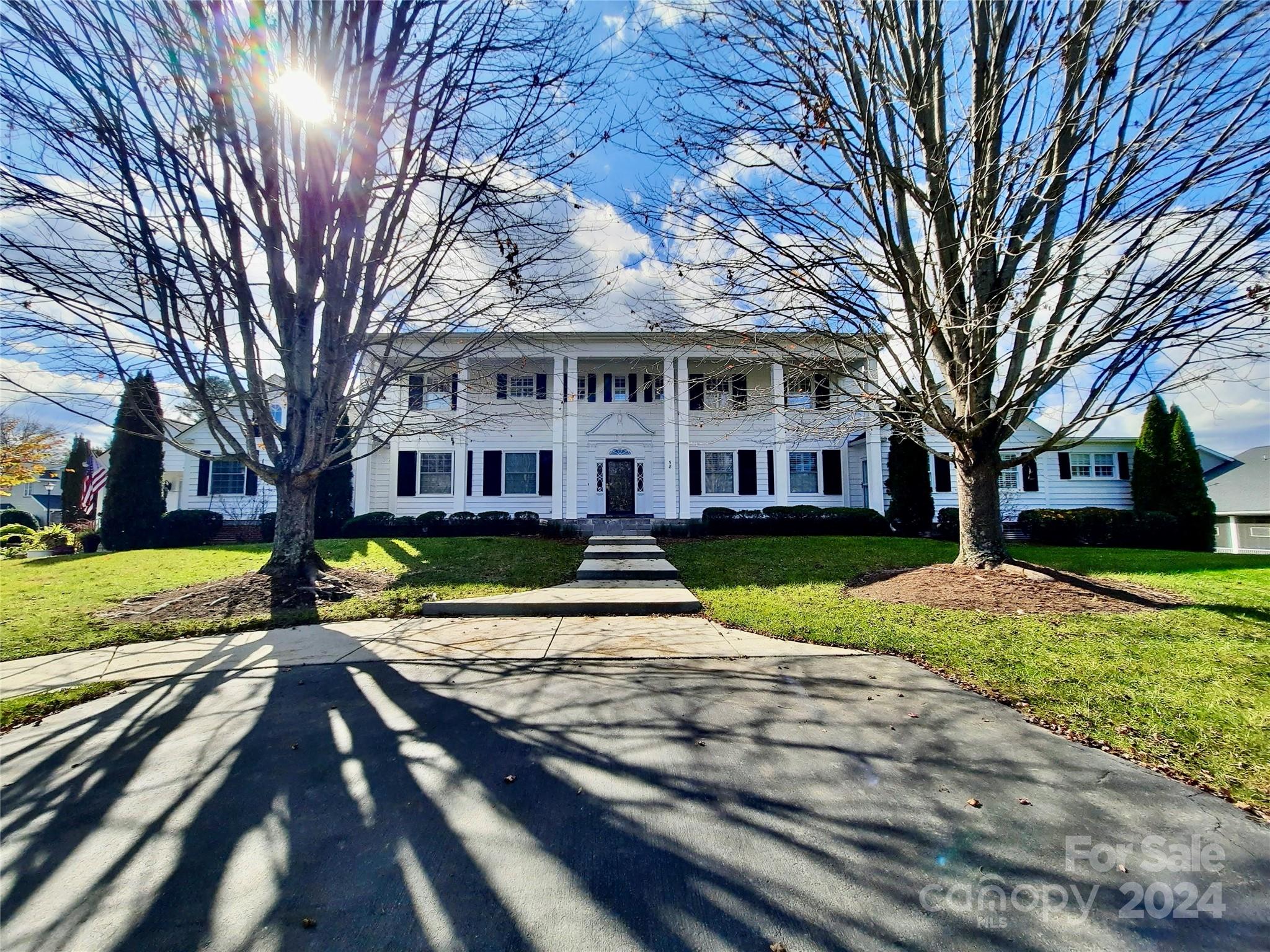 a view of a house with a yard covered with trees