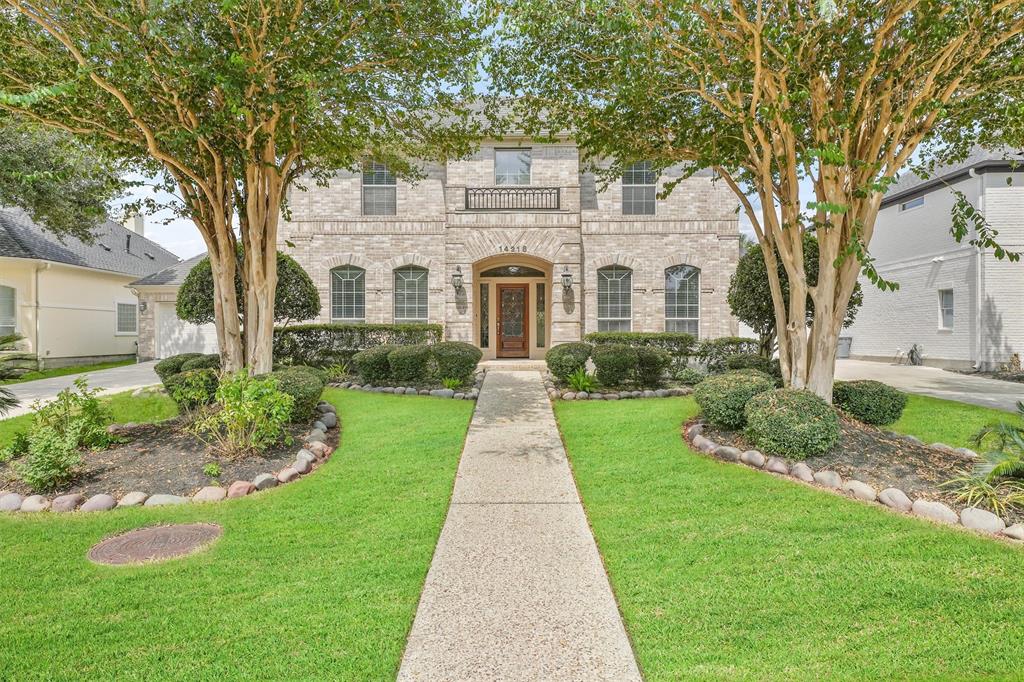 a front view of a house with a yard and potted plants