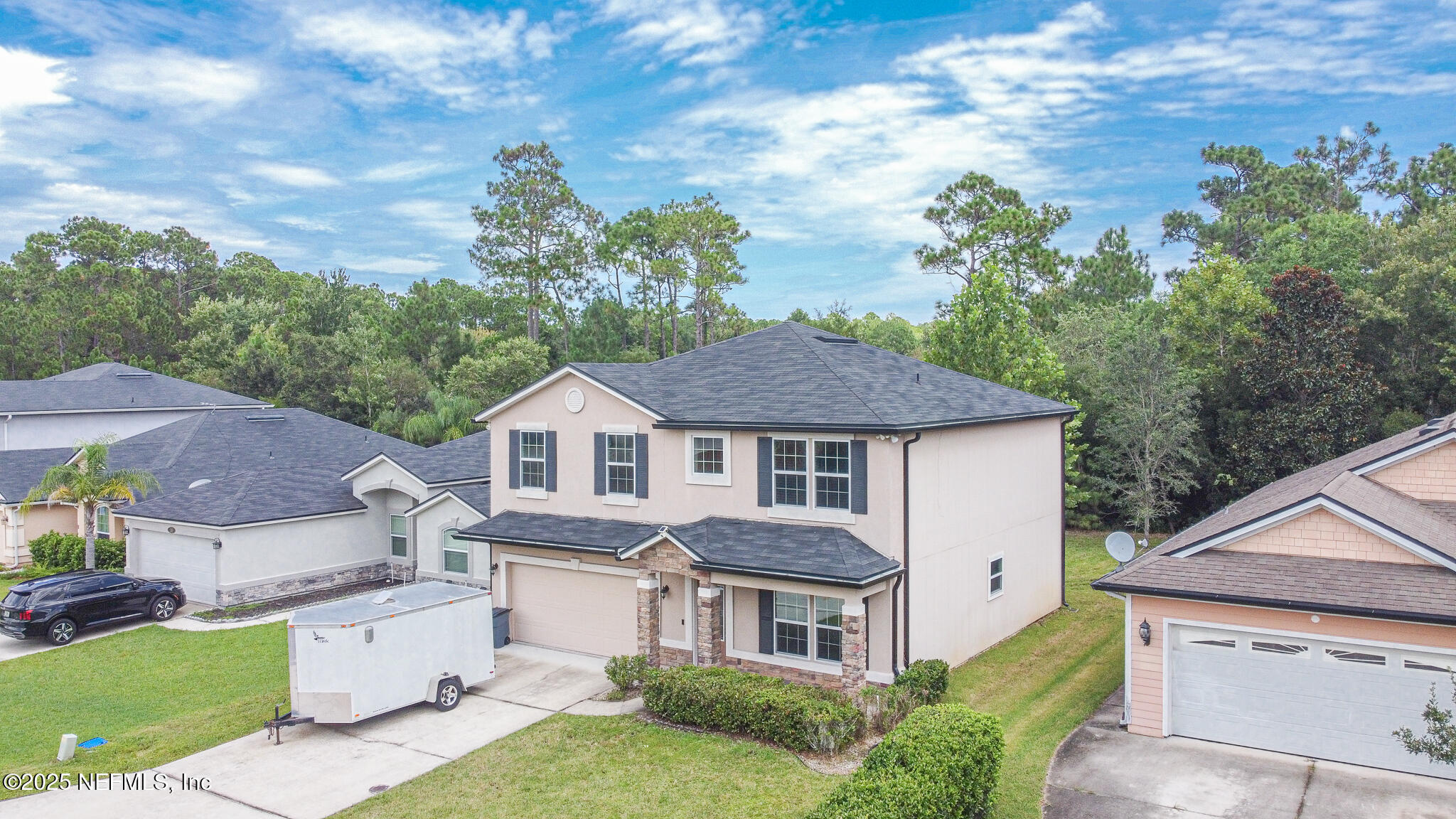 a aerial view of a house with a yard plants and large tree