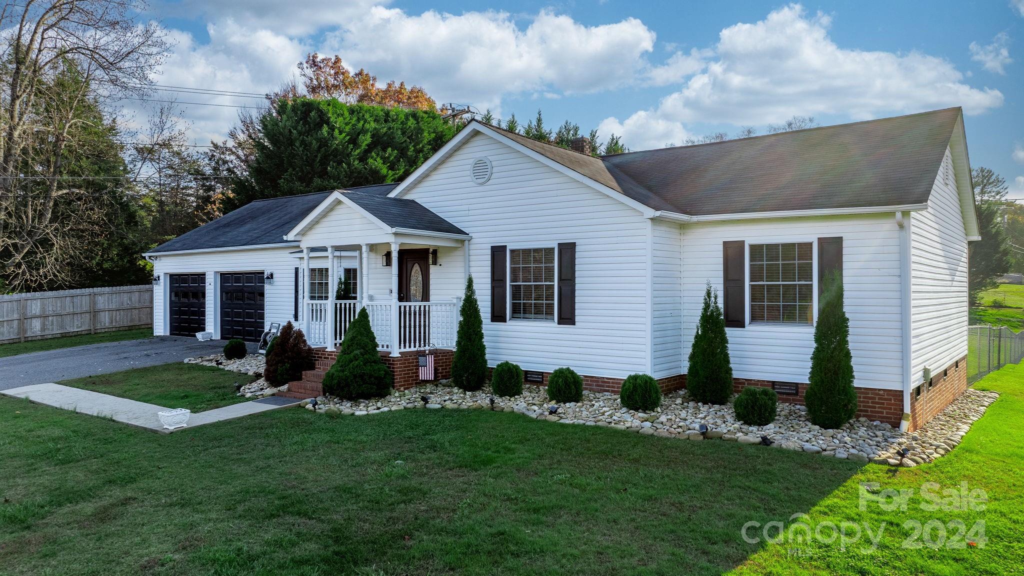 a front view of a house with a garden and yard