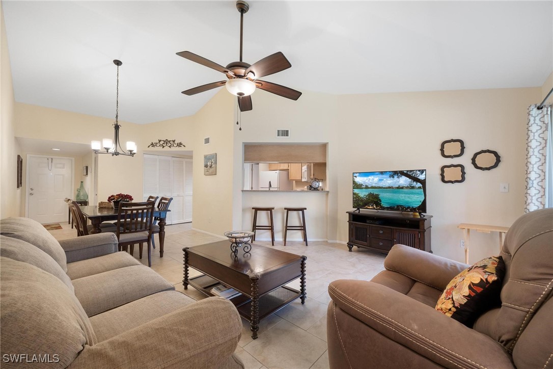 a living room with furniture a ceiling fan and a flat screen tv