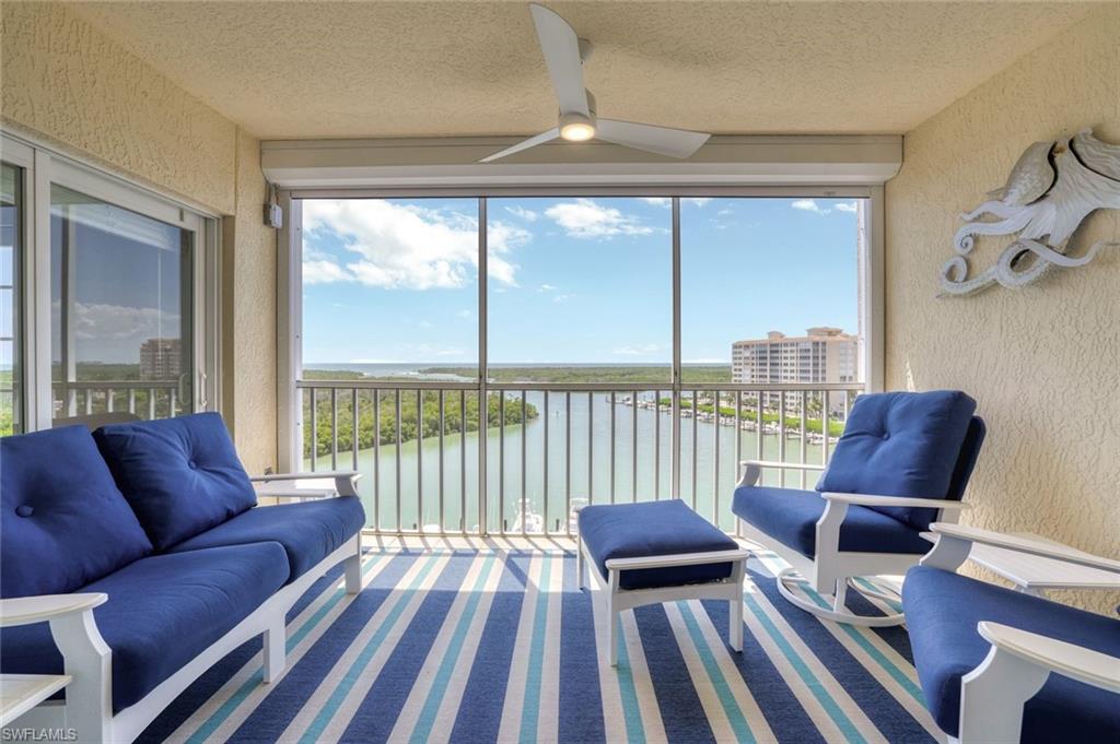 Sunroom with ceiling fan and a water view